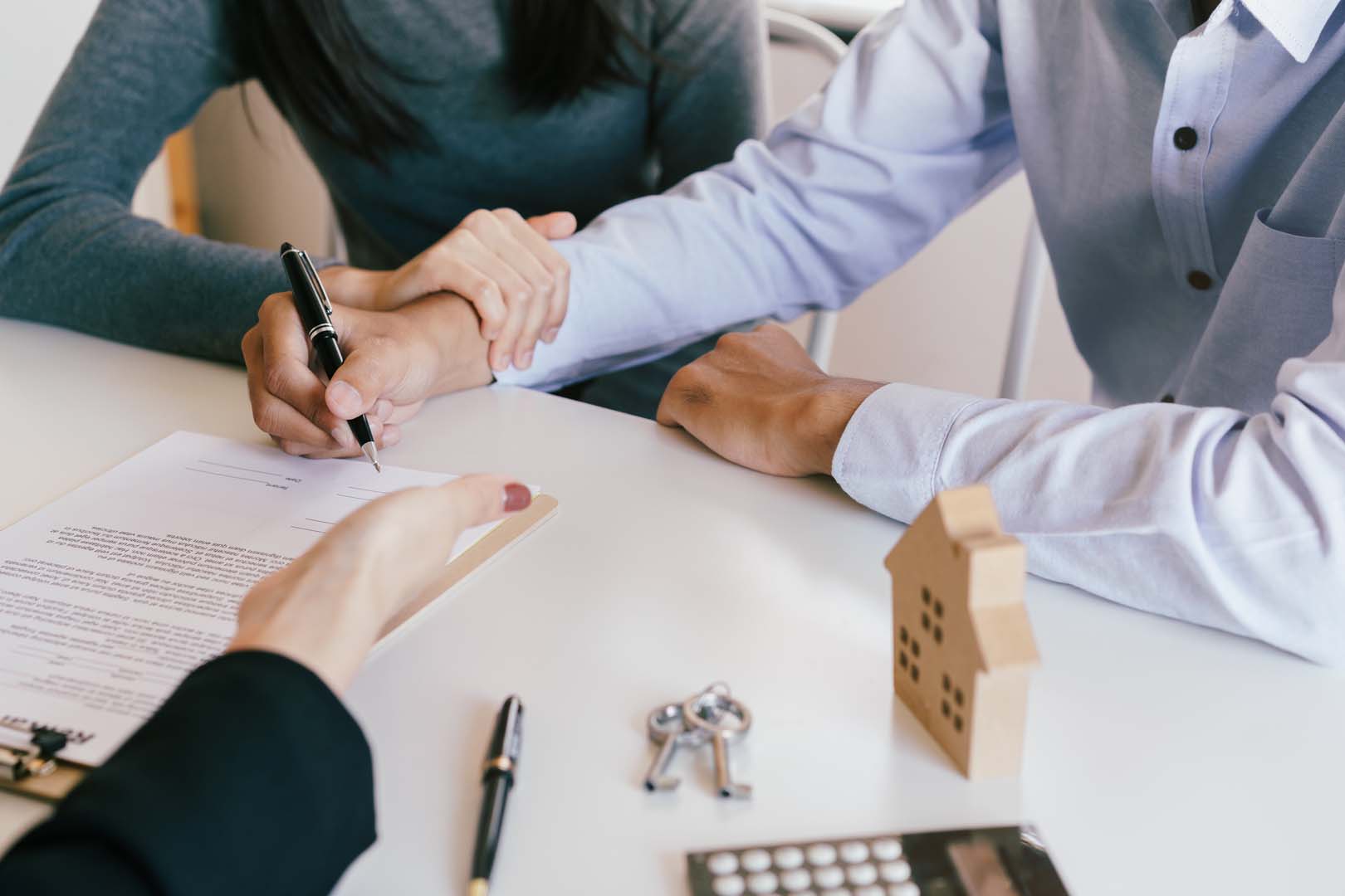 Customers signing a sales contract with an estate agent