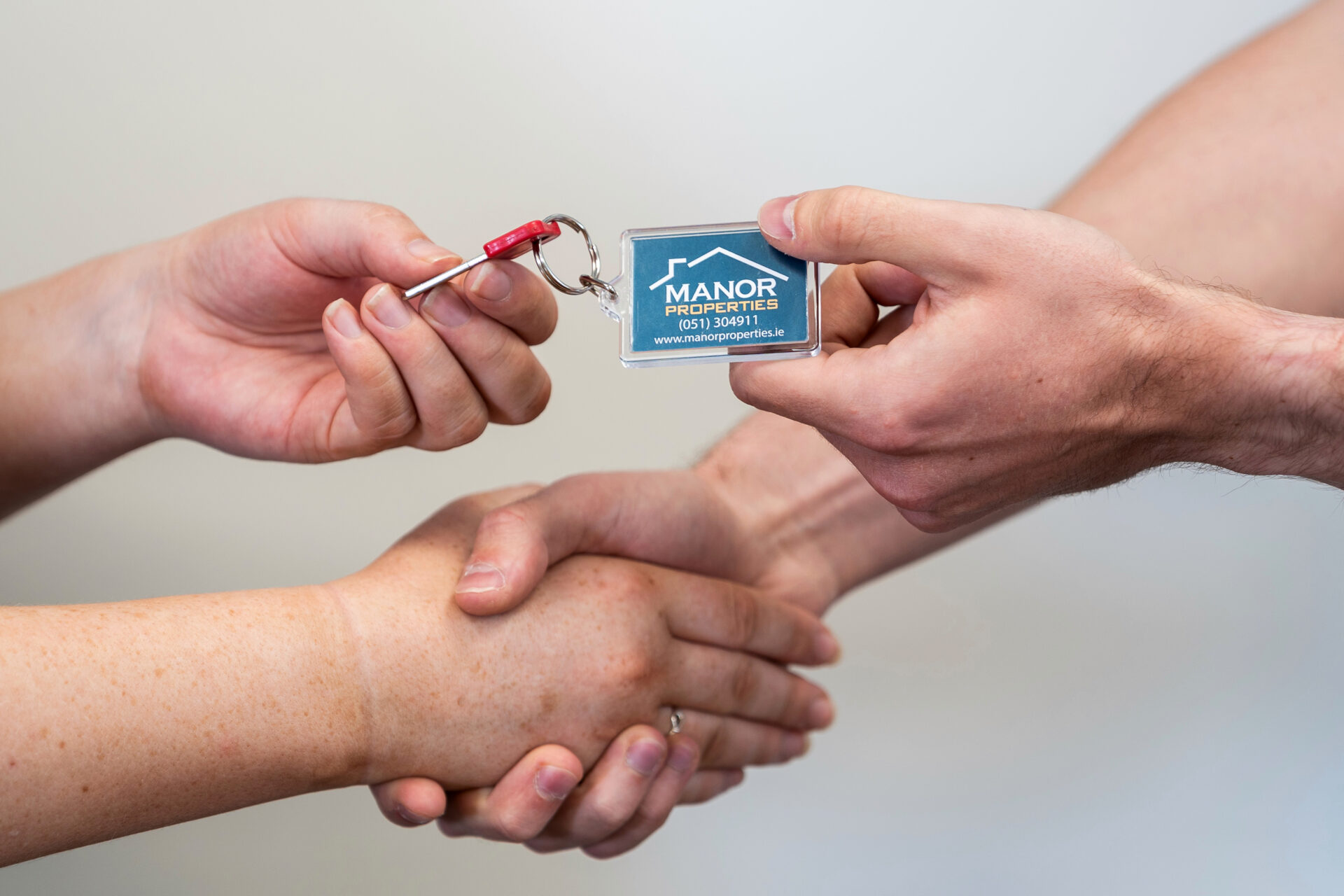 A Manor Properties keyring being handed over with a handshake